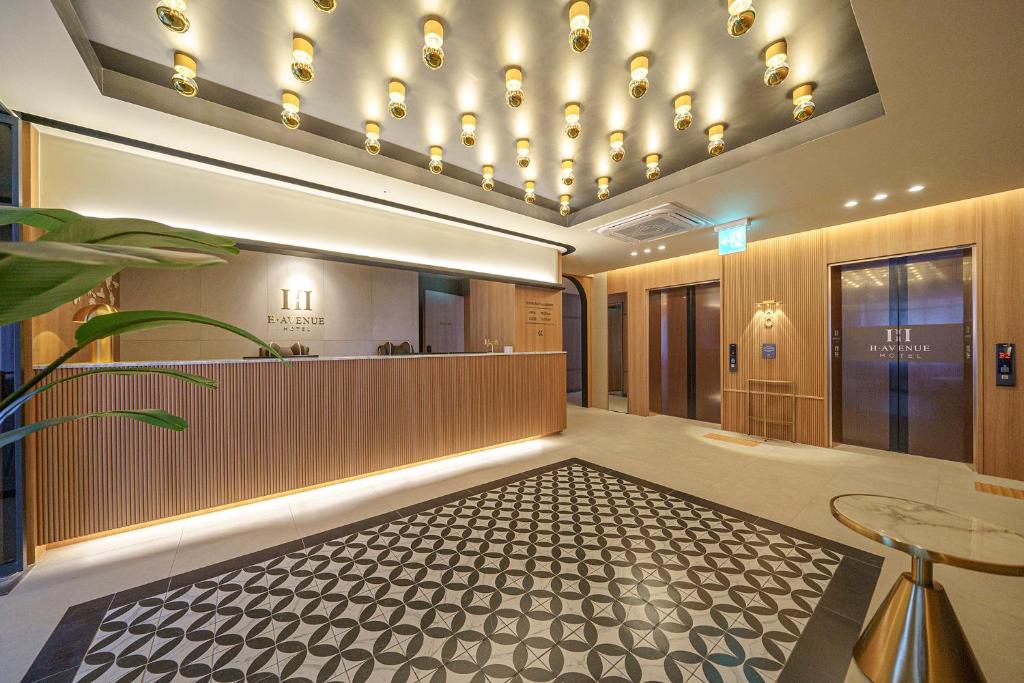 un vestíbulo con una zona de espera con una mesa y un mostrador en H-Avenue Hotel Geomdan New Town en Incheon