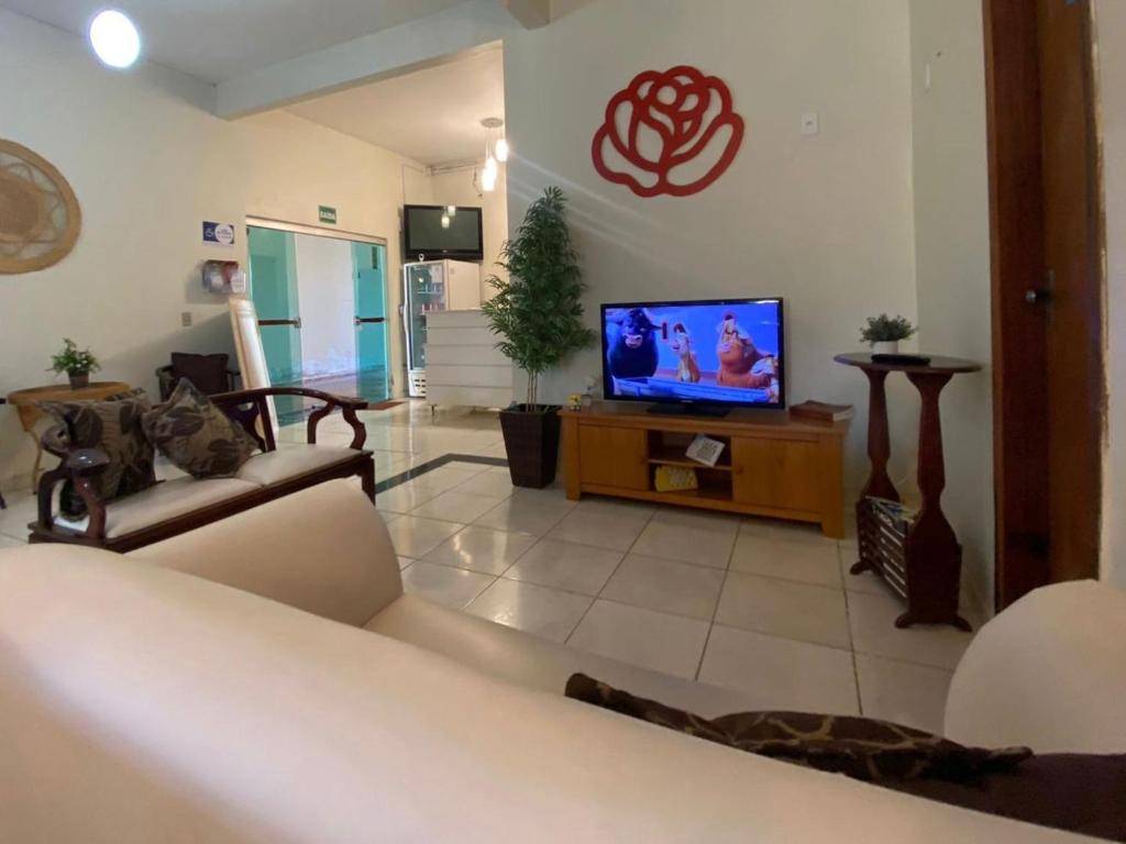 a living room with a couch and a television at Hotel HB in Planaltina