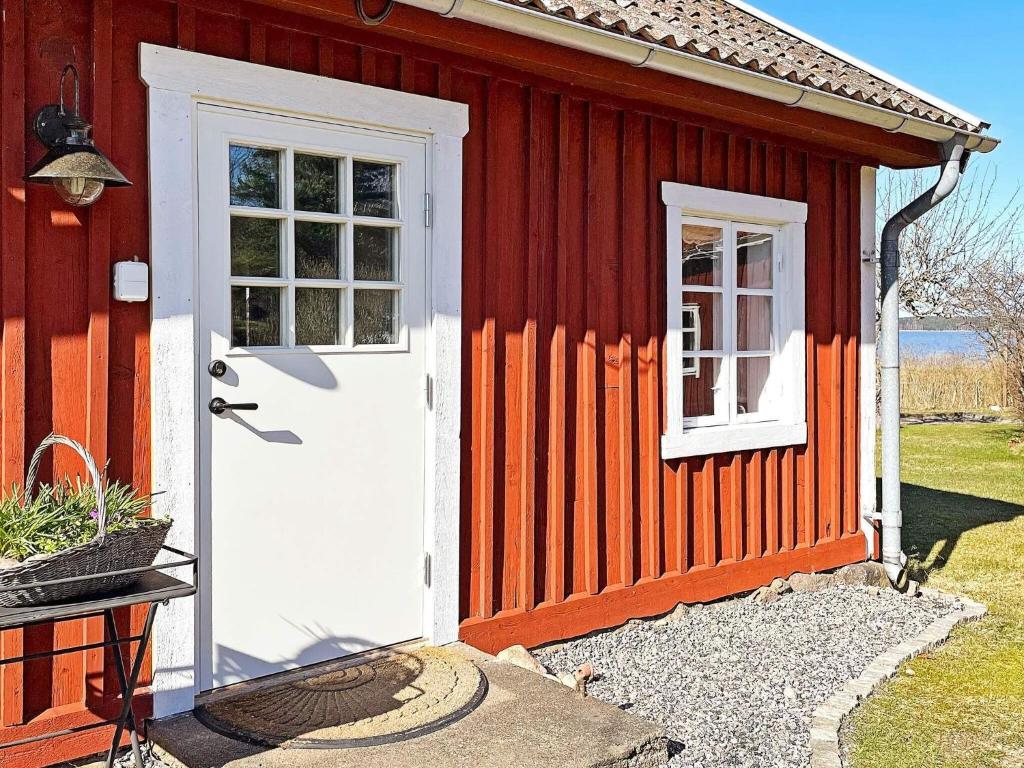 een rood huis met een witte deur en een raam bij Holiday home MARIESTAD X in Mariestad