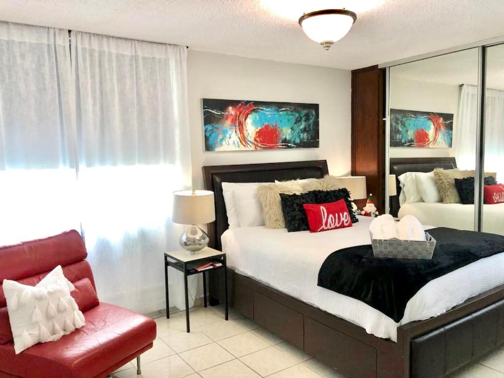 a bedroom with a large bed and a red chair at The Vue at Dos Marina in Fajardo