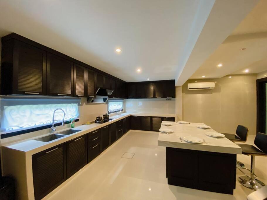 a large kitchen with a sink and a counter at C02 EuroStyle Seri Alam Homestay in Masai