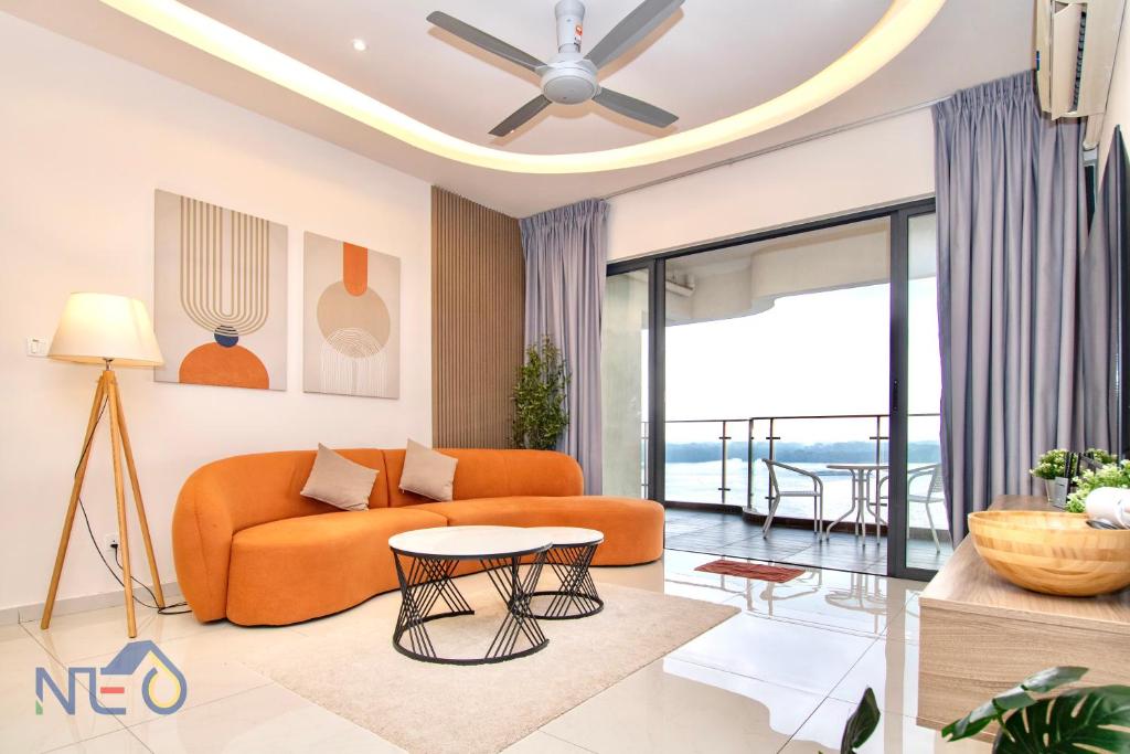 a living room with an orange couch and a ceiling fan at Country Garden Danga Bay InStyle Sea View Homestay Suite by NEO in Johor Bahru