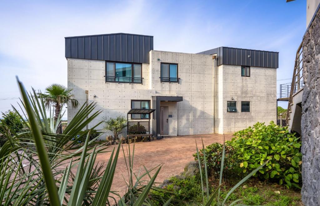 a brick house with a black roof at Eco Green Resort & Pool Villa in Jeju