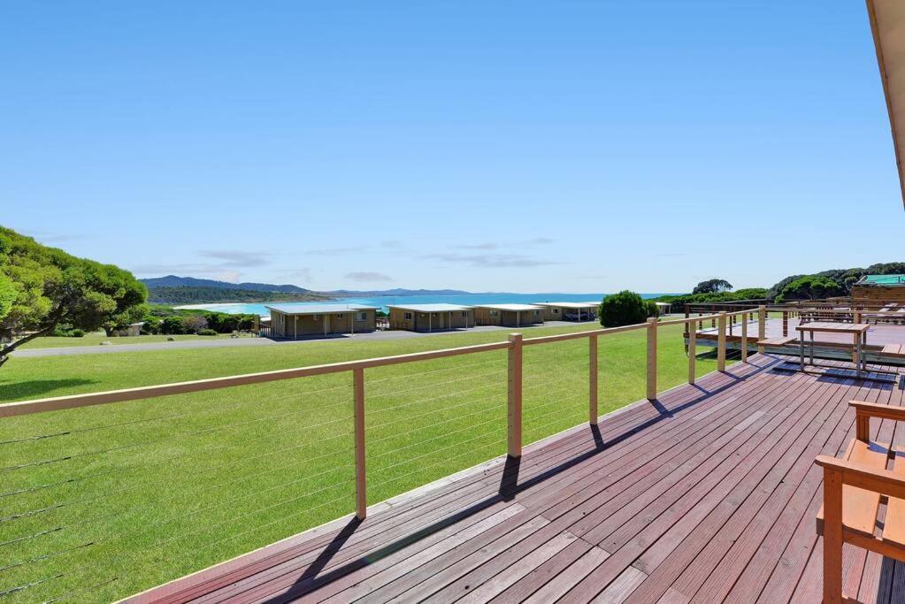 une terrasse en bois avec vue sur un champ dans l'établissement Marlo - White Sands Estate, à Four Mile Creek