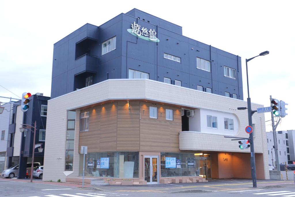 un edificio con un cartel en la parte superior en 遊悠館, en Chitose