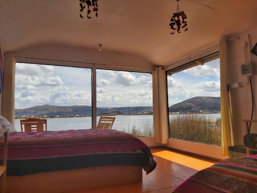 a bedroom with a bed and a view of the water at Titicaca Utama Lodge Perú in Puno