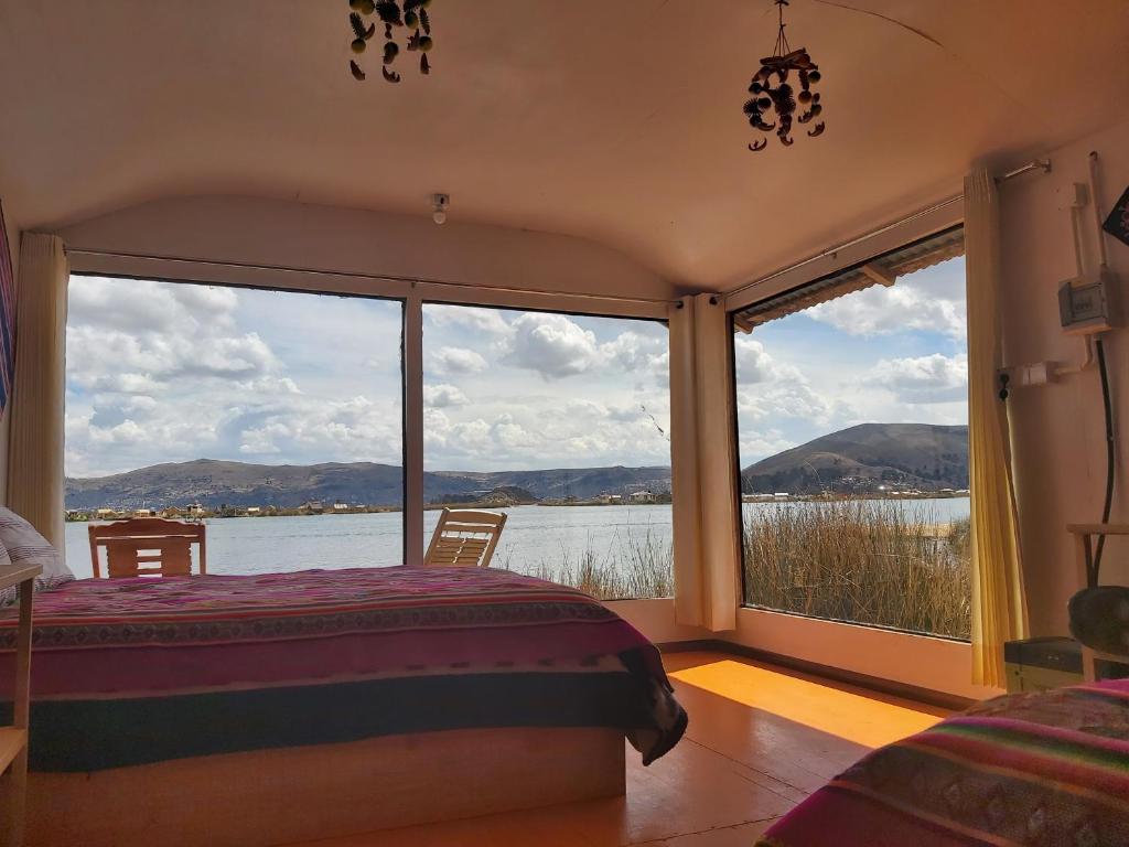 Schlafzimmer mit einem Bett und Blick auf das Wasser in der Unterkunft Titicaca Utama Lodge Perú in Puno