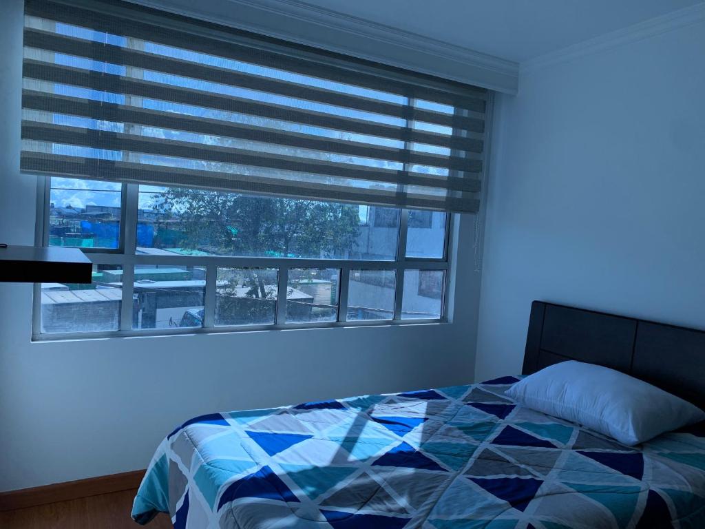 1 dormitorio con 1 cama y ventana con persianas en Bogotá Kings 300, en Bogotá