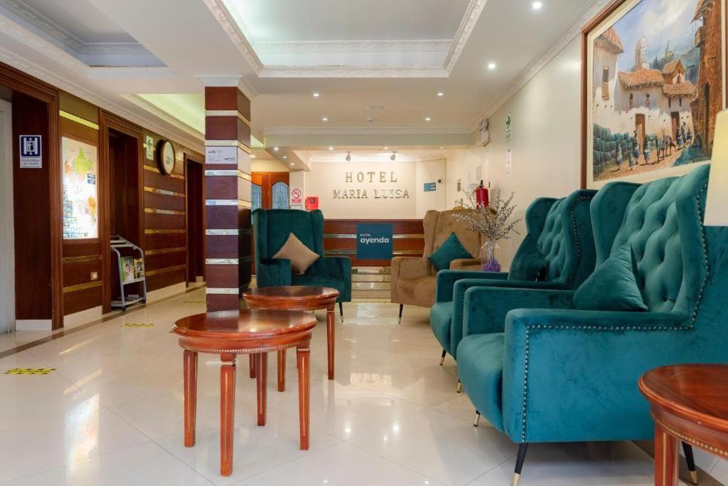 a waiting room with blue couches and tables at Hotel María Luisa in Lima