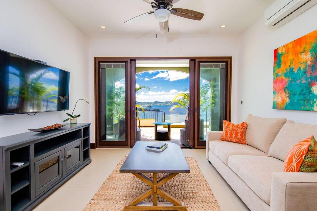 a living room with a couch and a tv at 360 Splendor 303-Ocean View Condo-Breakfast Included! in Playa Flamingo