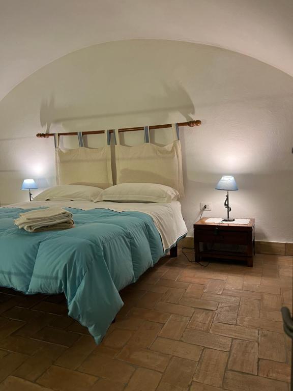 a bedroom with a large bed and two lamps at Wine & Roses in Mattinata