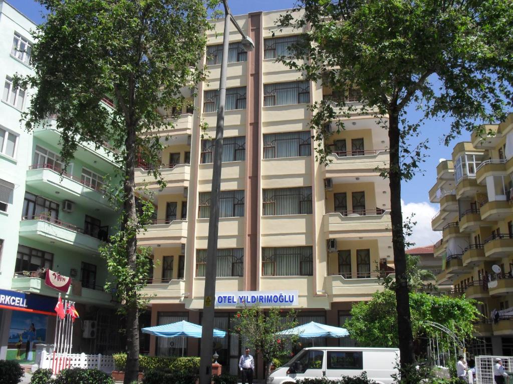 a large building with a white van parked in front of it at Hotel Yildirimoglu in Alanya