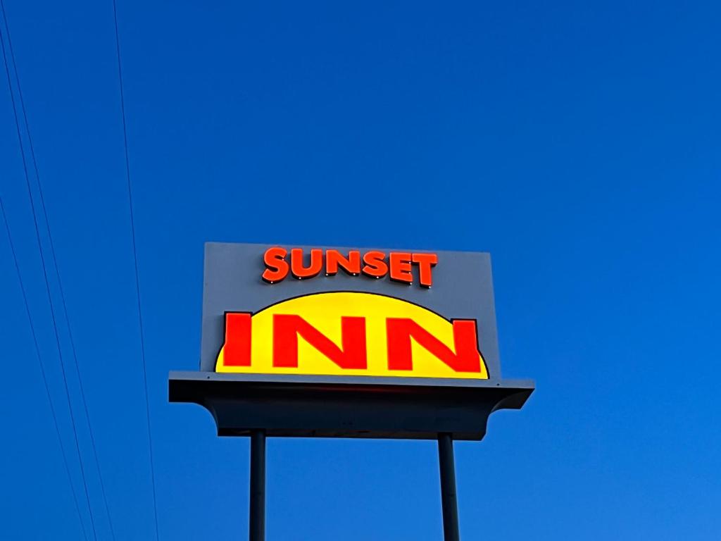 una señal para una puesta de sol Estoy en un cielo azul en Sunset Inn, en Grants Pass