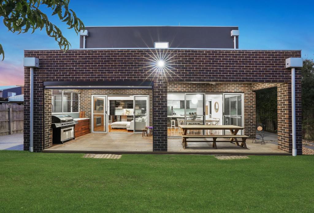 a brick house with a deck and a bench at Casa Di Mare - Portarlington in Portarlington
