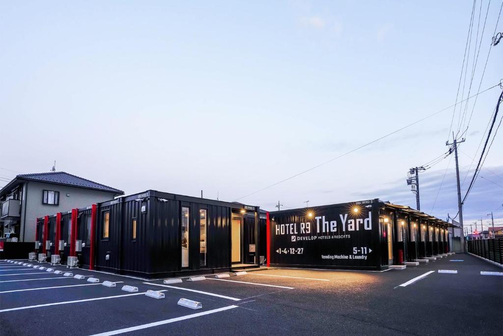 HOTEL R9 The Yard Yuki في Yuki: صف من حاويات الشحن في موقف للسيارات