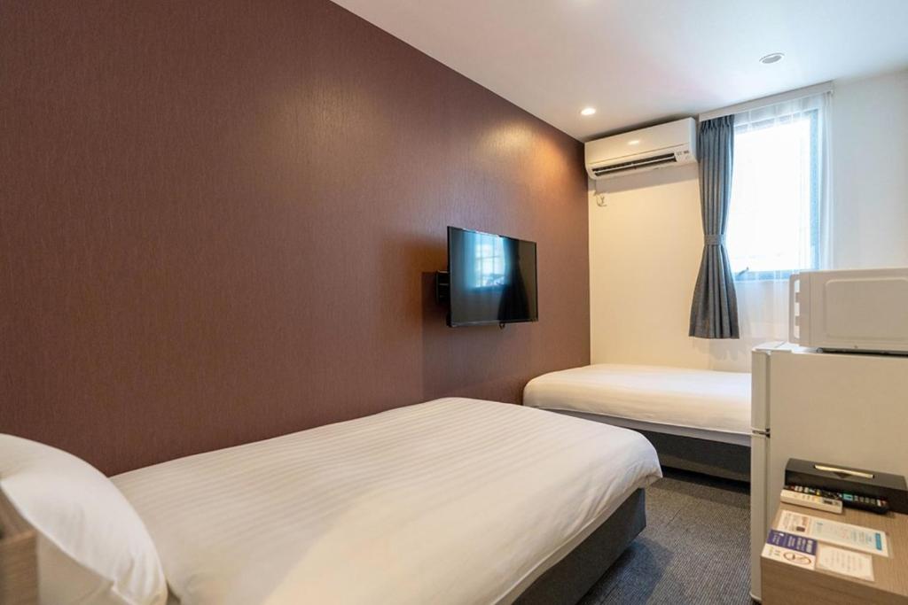 Postel nebo postele na pokoji v ubytování HOTEL R9 The Yard Yuki