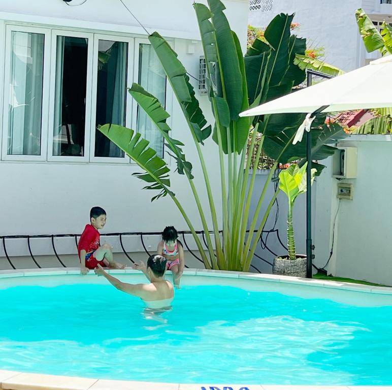 two children playing in a swimming pool at 5 Bedroom Villa in Vung Tau- Biệt thự 5 phòng Bãi sau- The Black & White Garden Villa in Xã Thang Tam