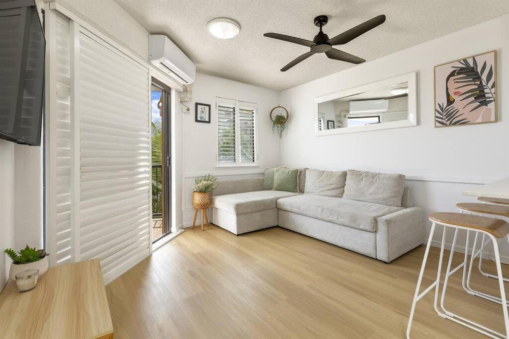 a living room with a couch and a ceiling fan at 1 Bedroom Central Mooloolaba Resort with Pool, Spa, Mini Golf in Mooloolaba