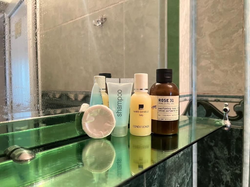 a bathroom counter with bottles of soap and a mirror at Bon Apart in Quba