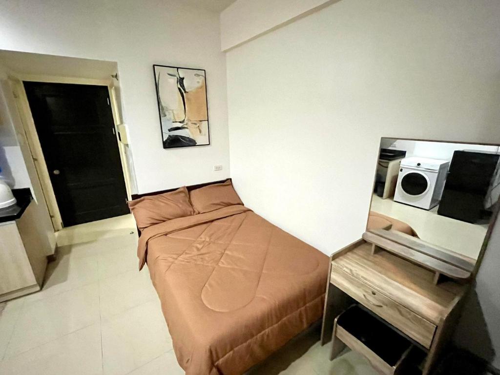 - une petite chambre avec un lit et une table dans l'établissement Mabolo Garden Flats 2309, à Cebu