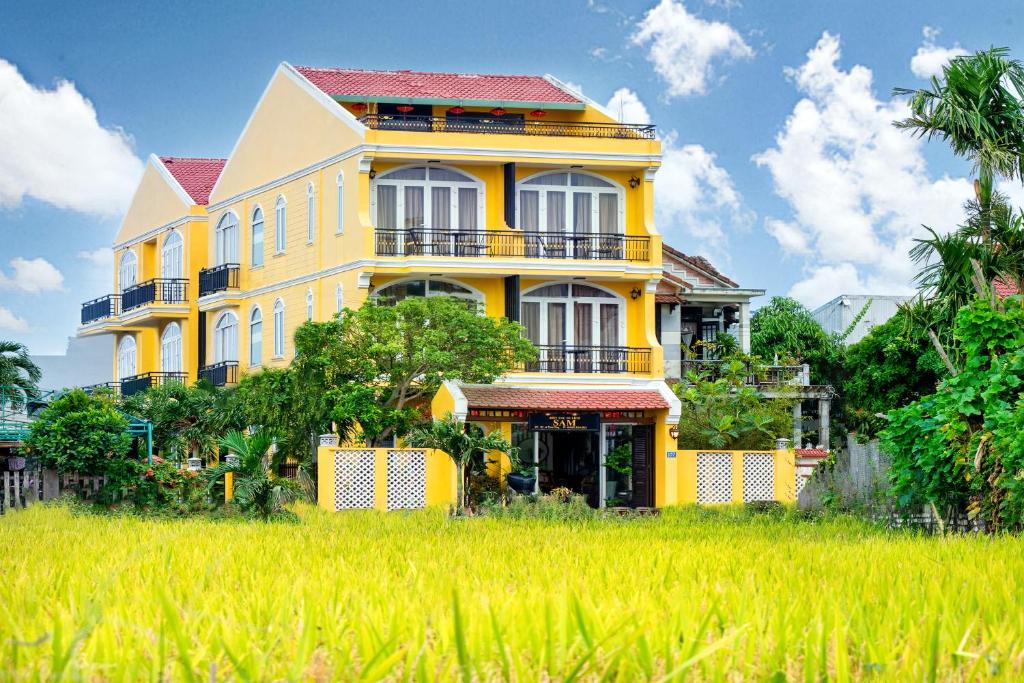 a yellow house in the middle of a rice field at Sam Retreat Villa in Hoi An