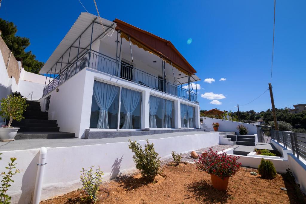 a white house with windows and plants in front of it at Oceanus Summer House in Salamina