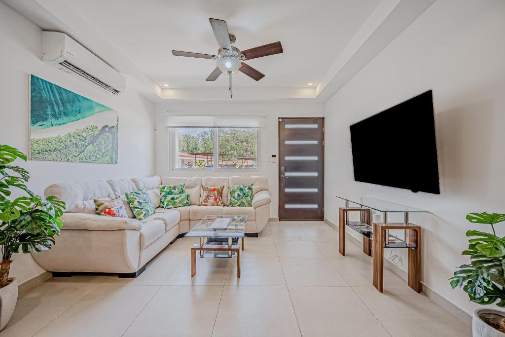 sala de estar con sofá y TV de pantalla plana en Jacarandas, 8 en Tamarindo