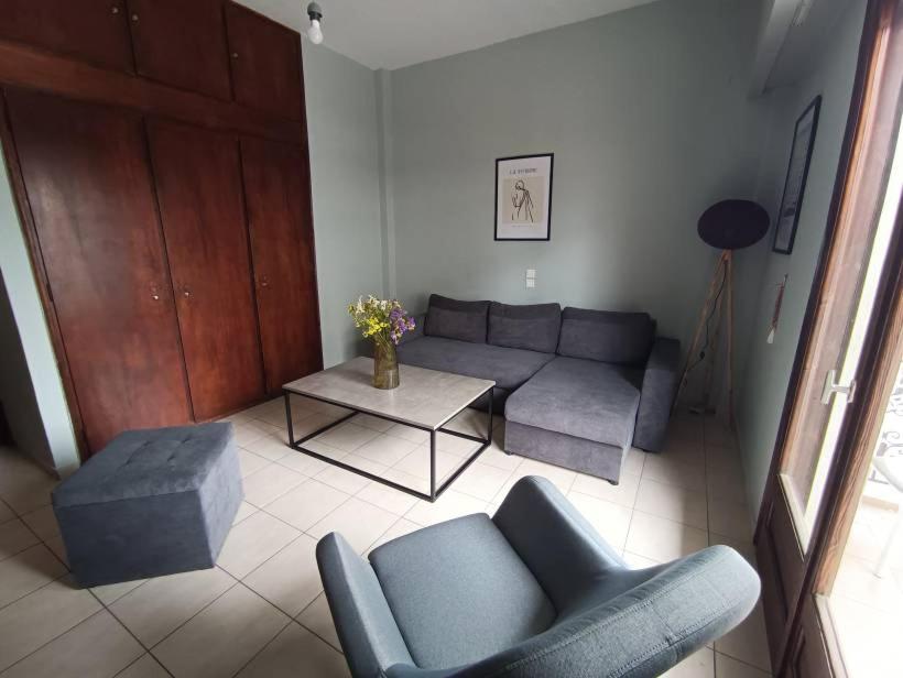 sala de estar con sofá y mesa en Appartment near centre, bus and train stations, en Pyrgos