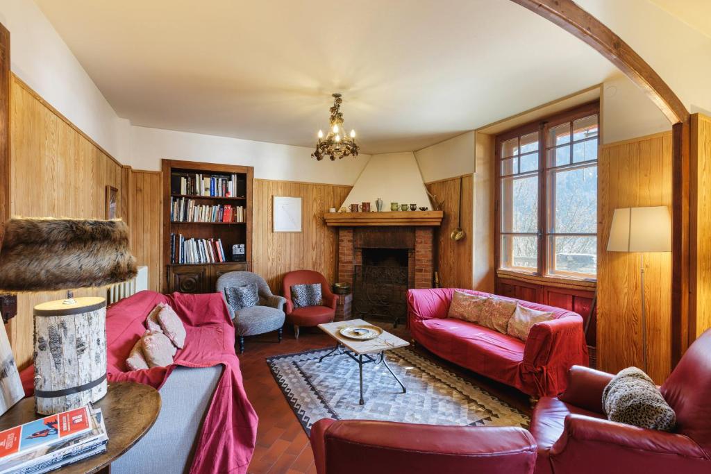 un salon avec des meubles rouges et une cheminée dans l'établissement Grand Chalet des Moussoux - Happy Rentals, à Chamonix-Mont-Blanc