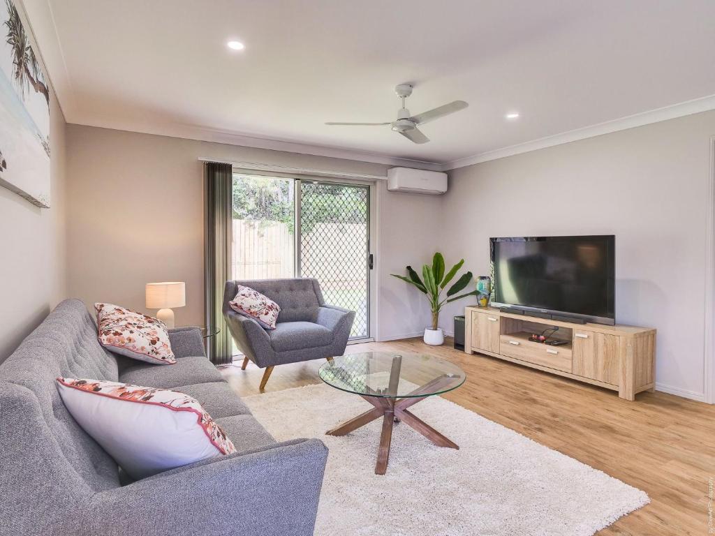 a living room with a couch and a tv at Breeze in Toogoom in Toogoom