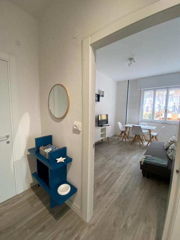 a living room with a blue shelf and a mirror at Loano: Centro e Mare a portata di mano in Loano