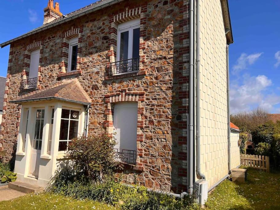 ceglany dom z 2 oknami i balkonem w obiekcie La Maison Familiale Ladou w mieście Barneville-Carteret
