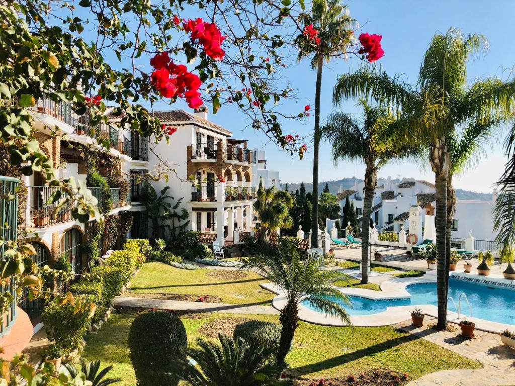 vista su un resort con piscina e palme di Luxury Puebla Aida with Golf & Sea View a Mijas Costa