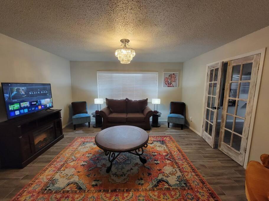 a living room with a couch and a table and a tv at Desert Oasis With Hot Tub! in Las Cruces