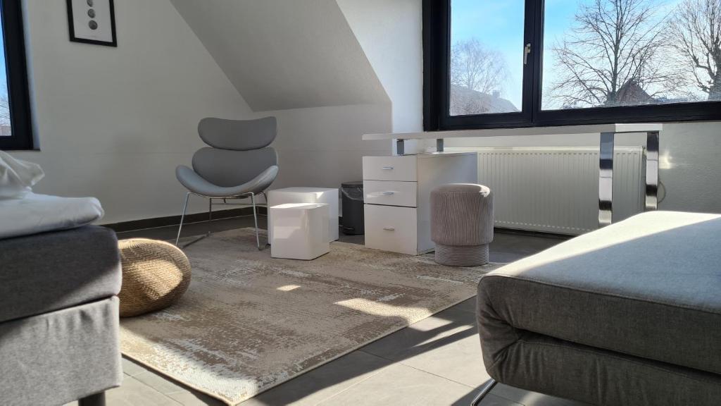 ein Schlafzimmer mit einem Sofa und einem Stuhl in einem Zimmer in der Unterkunft Plenus Apartment Airport Arsterdamm in Bremen