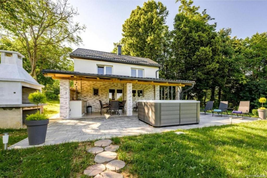 une arrière-cour avec une terrasse et une maison dans l'établissement Cozy House In Nature With Hot Tub - Happy Rentals, à Kelemen