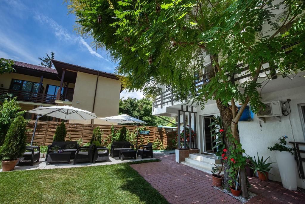 a patio with chairs and umbrellas next to a house at Casa Amur in Jupiter