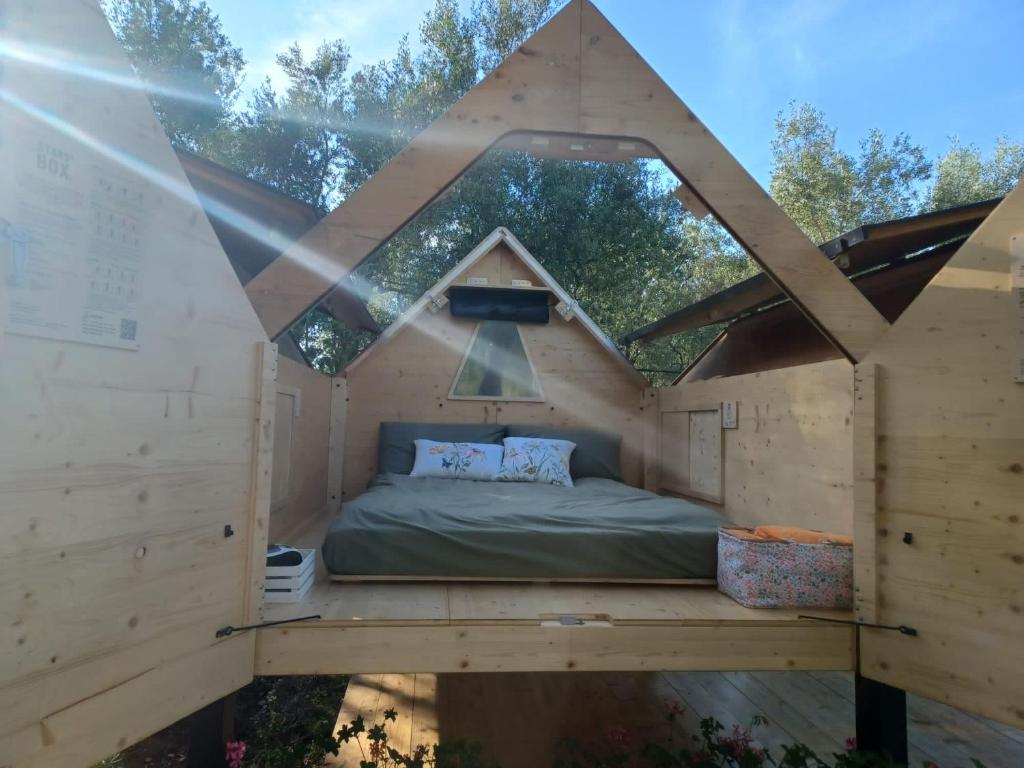 Bett in einem Holzhaus mit einem großen Fenster in der Unterkunft #StarsBoxtragliulivi in Molfetta