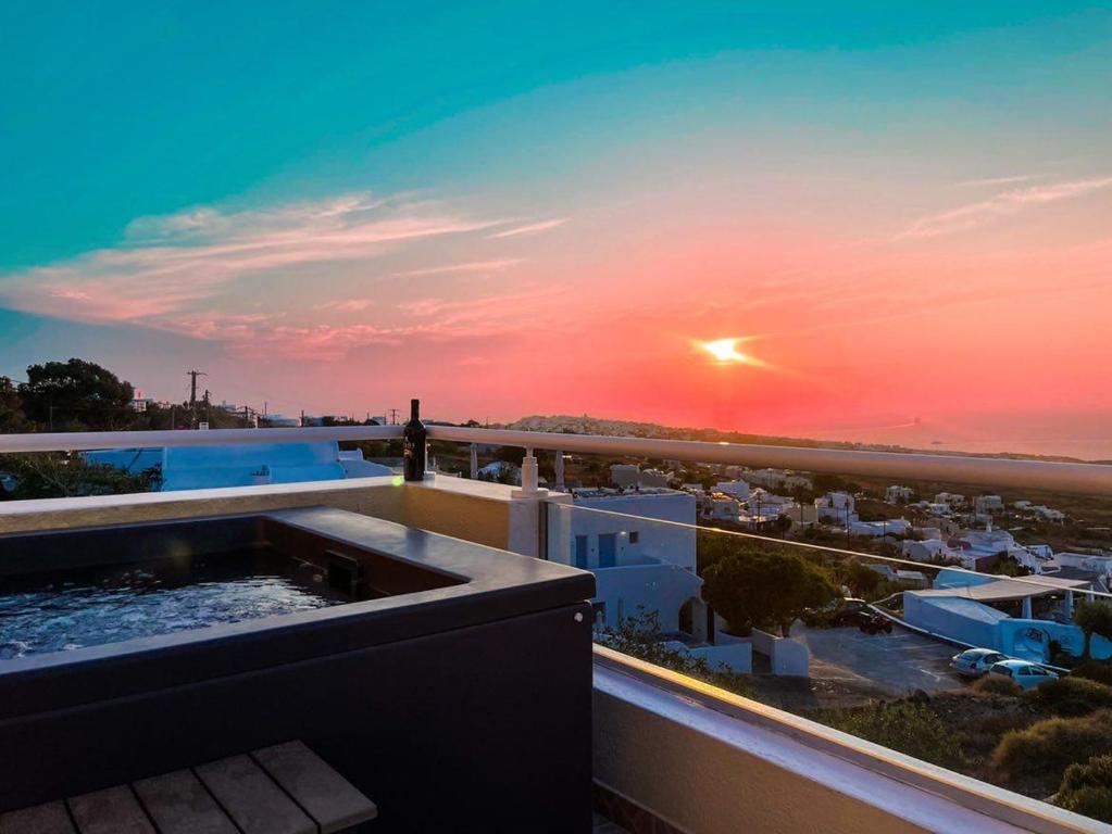 una vista sul tramonto dal balcone di un edificio di Kiklamino Sunset Studios a Oia