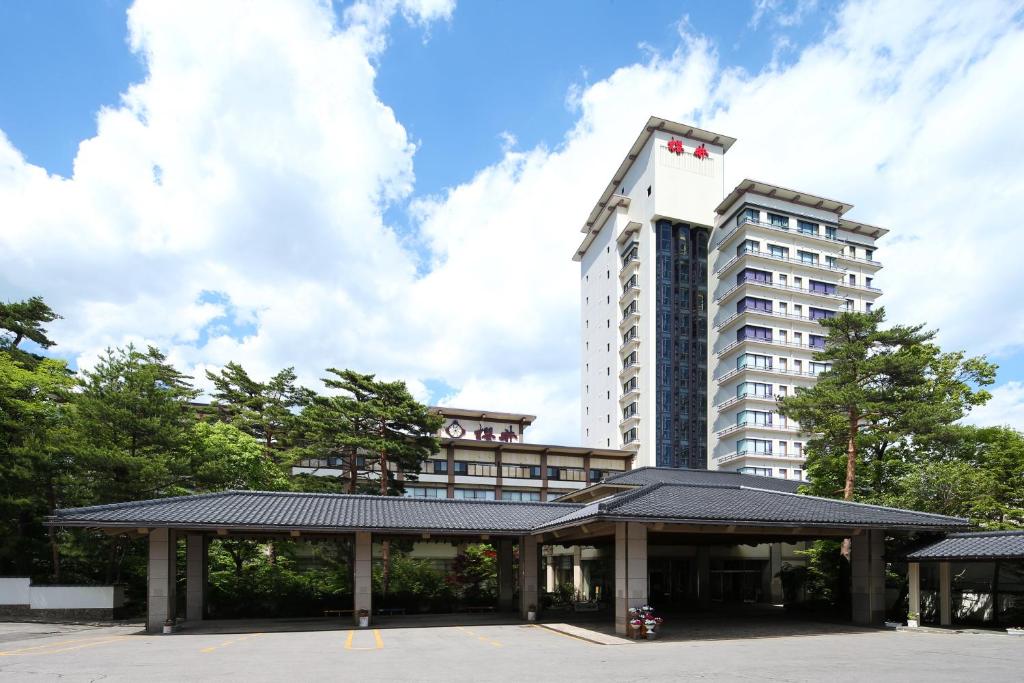 a hotel with a parking lot in front of a building at Hotel Sakurai in Kusatsu