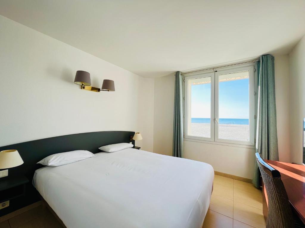 パラヴァ・レ・フロにあるLes Alizesのベッドルーム(大きな白いベッド1台、窓付)