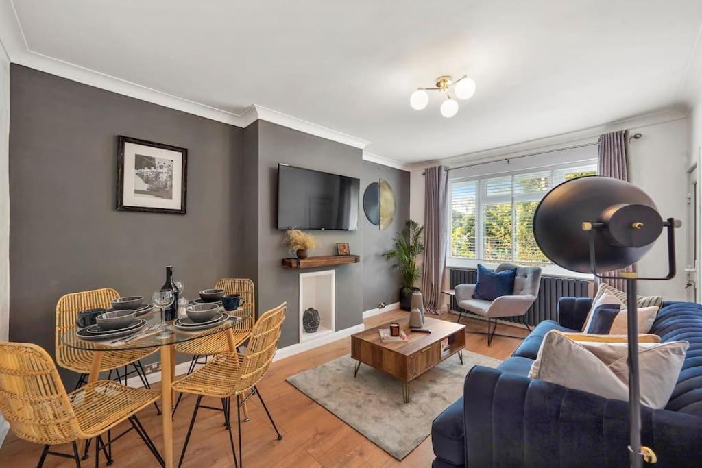 a living room with a blue couch and a table at Stylish Maisonette near the heath with Free parking & Wi-Fi in Kent