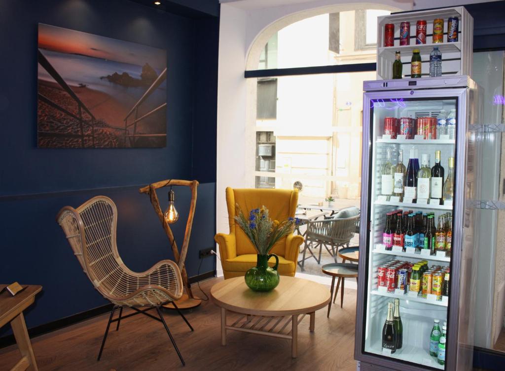 カンヌにあるCharlie's Hôtel Cannesの冷蔵庫、椅子、テーブルが備わる客室です。
