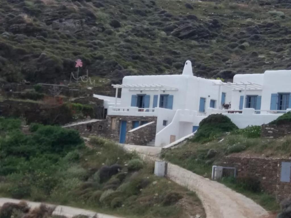uma casa branca numa colina com uma estrada de terra em Villa Niloya Kythnos em Loutrá