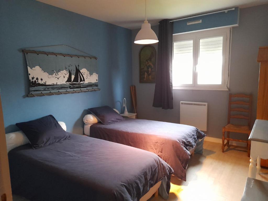 een slaapkamer met 2 bedden en een raam bij Kermarco in Trégourez