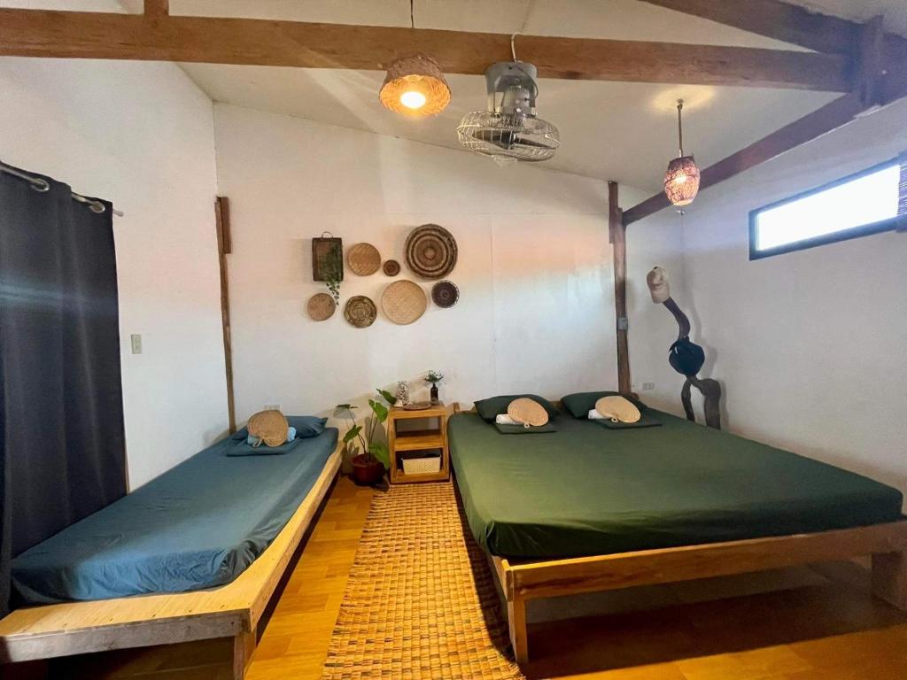 a room with two beds and a table at Casita Francisco Siargao in General Luna