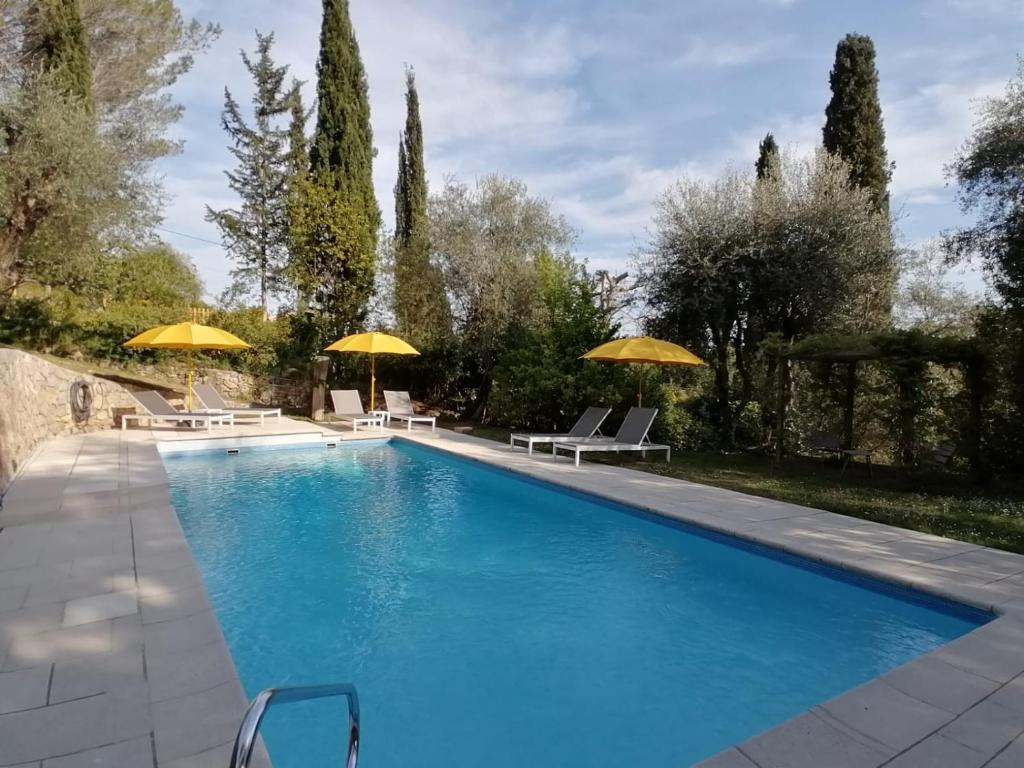 une piscine avec chaises et parasols dans une cour dans l'établissement LA PERASCEDA, à Spéracèdes