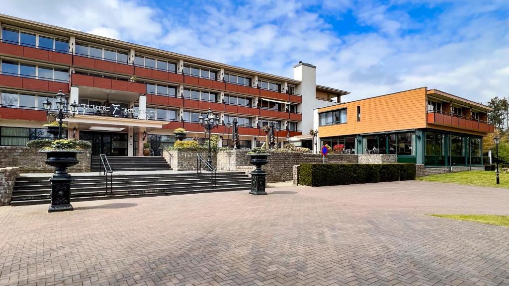 a building with two black posts in front of it at Fletcher Familiehotel De Hunzebergen in Exloo