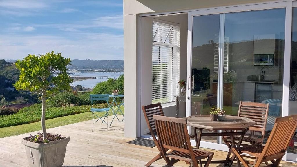 a patio with a table and chairs on a balcony at Knysna Private Estate Lagoon Apartment - Garden Apartment - Secure Estate in Knysna