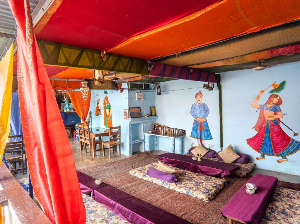 una sala de estar con una cama y una pintura en la pared en Singhvi's Haveli, en Jodhpur